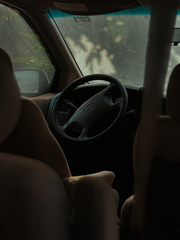 Moody car interior view featuring a steering wheel and seats.